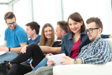 Kız üniversite öğrencisi lobide ve ta oturan arkadaş grubu