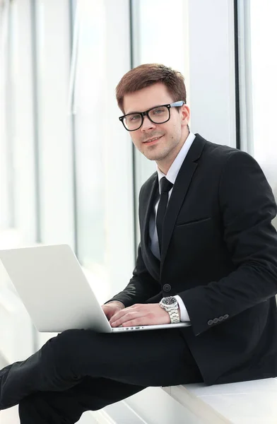 Närbild - en framgångsrik affärsman-bloggare med en laptop sitter — Stockfoto