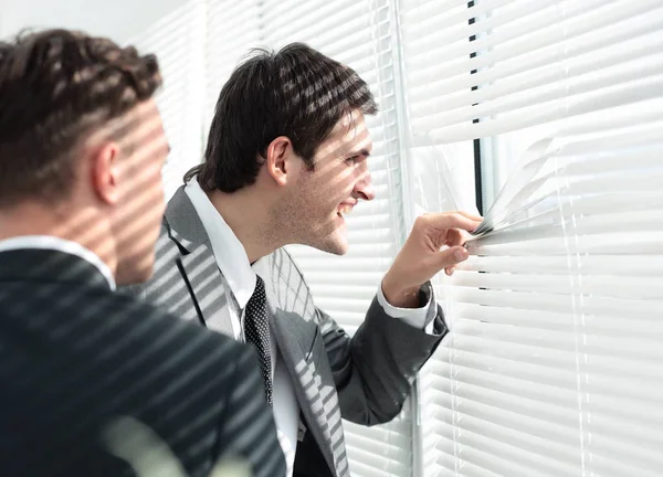 Office life:the curious office staff pushes the blinds and looki — Stock Photo, Image