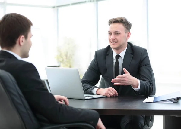 Gestionnaire assis derrière le bureau et parle au client — Photo