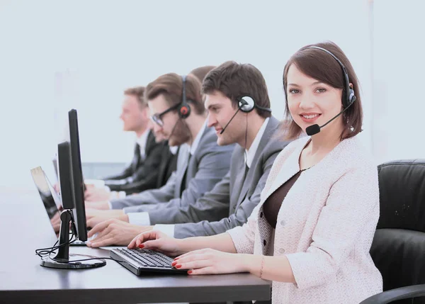 Assistente mulher bonita com um fone de ouvido em um call center no — Fotografia de Stock