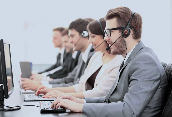 Operadores com fones de ouvido na frente de computadores no call center — Fotografia de Stock