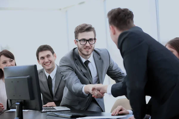 Parceiros de negócios perto de sua mesa para apertar as mãos como um sinal de coo — Fotografia de Stock