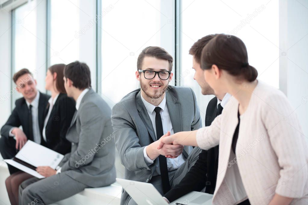 closeup of the employee welcomes colleague with a handshake befo