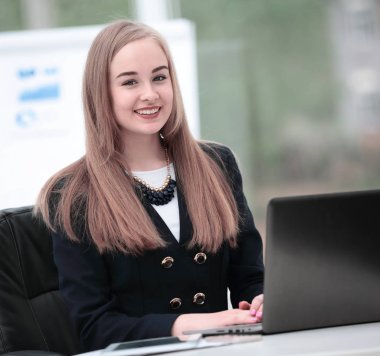 Modern ofis dizüstü bilgisayarda çalışan mutlu genç iş kadını