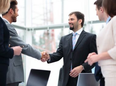 T ile iş toplantısında el sıkışan iki iş adamları