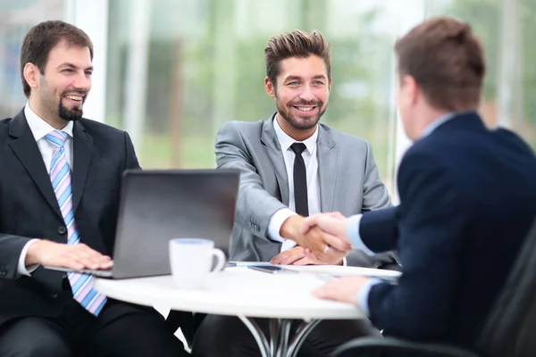 Two business people shaking hands and looking at each other with — Stock Photo, Image