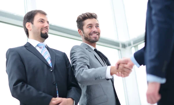 Двоє бізнесменів потискають один одному руки в офісі — стокове фото