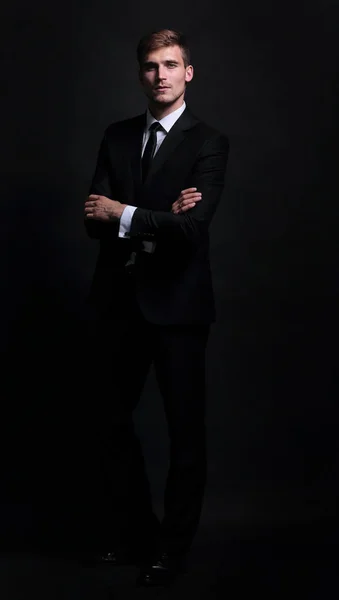 Happy business man klädd i svart kostym står och hopfällbara armar — Stockfoto