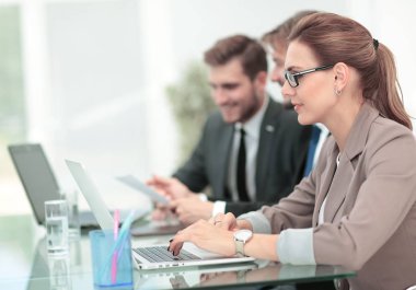 Modern ofiste masanın etrafında çalışan iş adamları.