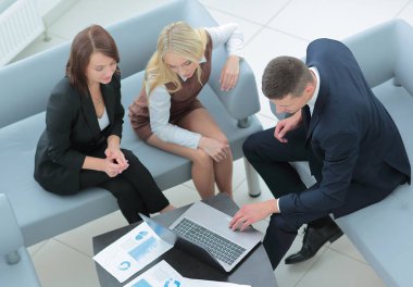 Modern ofiste masanın etrafında çalışan iş adamları.