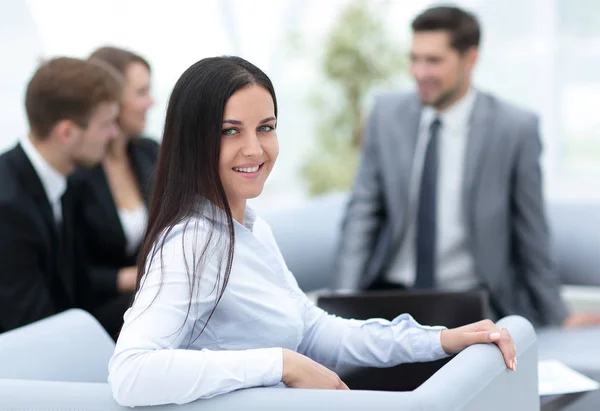 Porträt einer Geschäftsfrau, die im Hintergrund in die Kamera blickt — Stockfoto