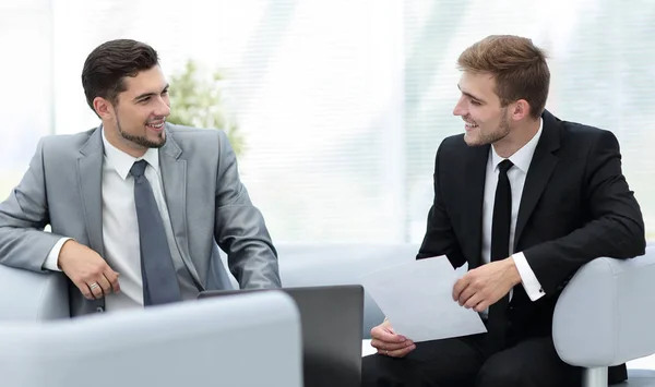 Dos hombres de negocios exitosos discutiendo documentos en un moderno off —  Fotos de Stock