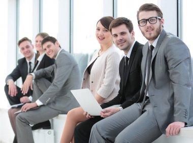 Ofiste toplantı sırasında kameraya bakarak zarif ortak çalışanlar