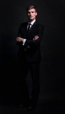 Mutlu iş adamı ayakta ve silah katlama siyah takım elbise