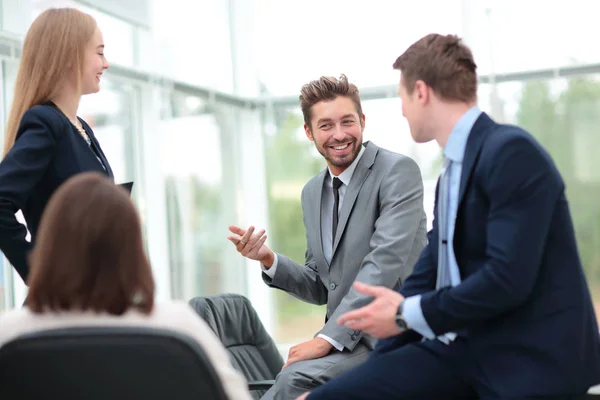 Compañeros alegres sonriendo mientras discuten algo en moderno — Foto de Stock