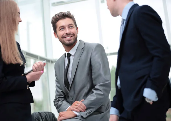 Compañeros alegres sonriendo mientras discuten algo en moderno — Foto de Stock