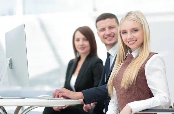 Elegante medewerkers camera kijken tijdens de bijeenkomst in office — Stockfoto