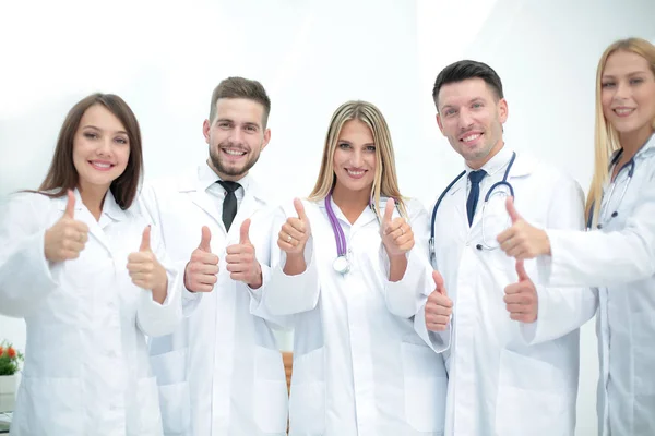 Smiling team of doctors at hospital making selfie and showing th — Stock Photo, Image