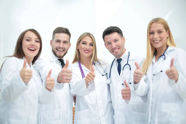 Smiling team of doctors at hospital making selfie and showing th — Stock Photo, Image