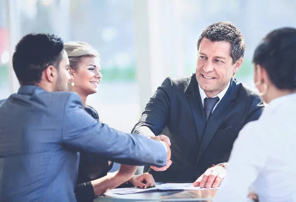 Homme d'affaires mature serrant la main pour conclure un accord avec son partenaire et ses collègues dans un bureau moderne — Photo