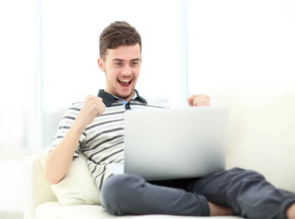 Man Relaxing on Sofa with Laptop Computer Stock Image