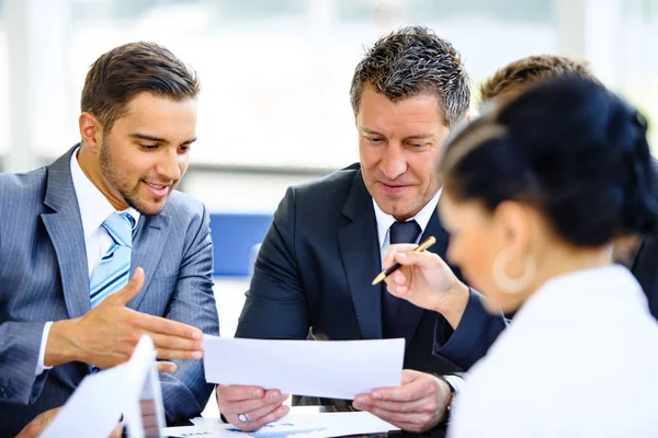 Socios comerciales que discuten documentos e ideas en la reunión — Foto de Stock