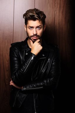 Sakallı yakışıklı emin olgun adam ahşap kahverengi üzerine duruyor