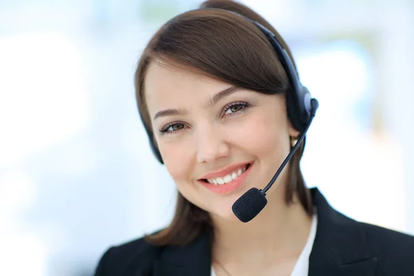 Joyeux jeune femme travaillant au centre d'appels, en utilisant un casque — Photo