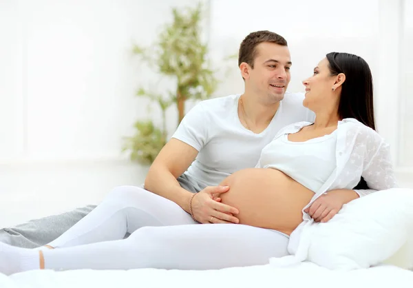 Пара с беременной женщиной отдыхают на диване вместе — стоковое фото