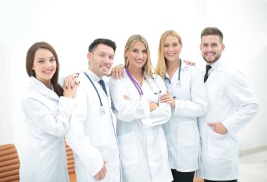 Poz ve kameraya gülümseyen emin doktorlar