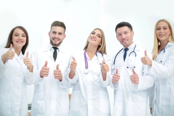 Médicos felizes sorrindo e mostrando os polegares para cima . — Fotografia de Stock