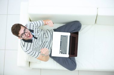 Mutlu genç adam, onun dizüstü bilgisayar kullanarak yakın çekim.