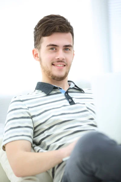 Felice giovane uomo utilizzando il suo computer portatile in luminoso soggiorno . — Foto Stock