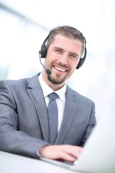 Porträt eines Geschäftsmannes, der an seinem Schreibtisch mit Headset arbeitet und — Stockfoto