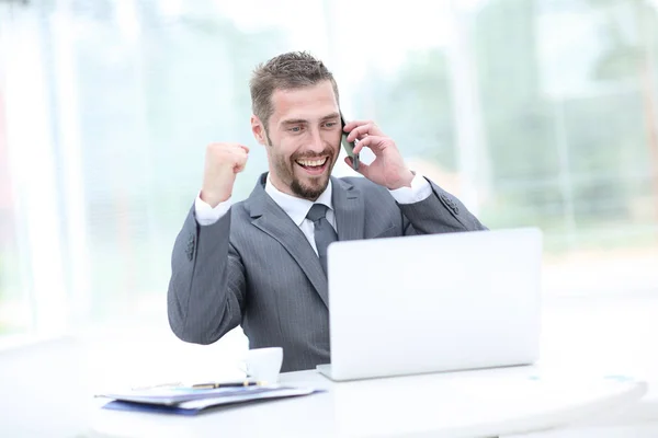 Ευτυχισμένος χαμογελώντας επιχειρηματίας δουλεύει με το laptop και καλώντας. — Φωτογραφία Αρχείου