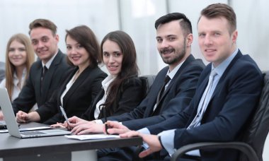 İş ekibi konferans odasındaki masada oturuyor.