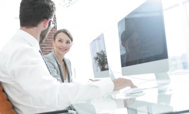 bir masanın arkasında oturan yaratıcı tasarımcılar