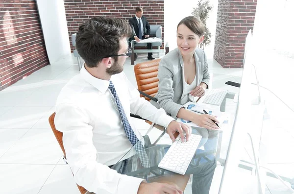 Giovani professionisti seduti dietro una scrivania — Foto Stock