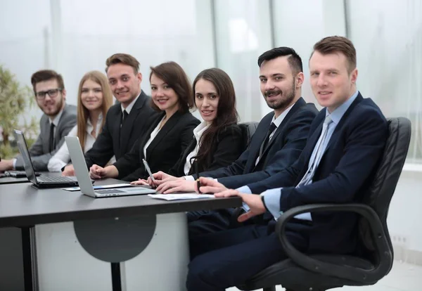 İş ekibi konferans odasındaki masada oturuyor.