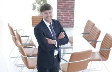 Bir boş toplantı odasında duran iş adamı