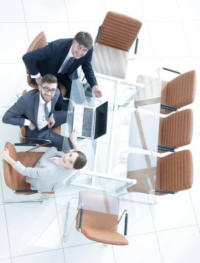 Çalışanlar masada oturup bakıyorlar.