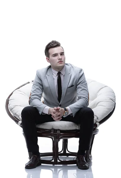 Tired businessman sitting in a round chair made of rattan — Stock Photo, Image