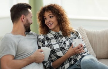 Güzel çift içecek bir fincan cou üzerinde otururken holding