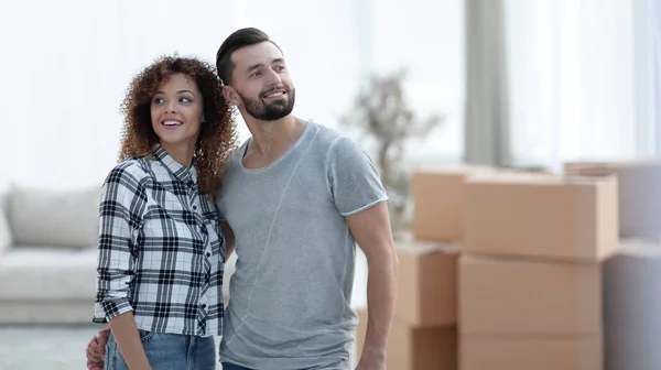 Casal feliz em pé na nova sala de estar — Fotografia de Stock