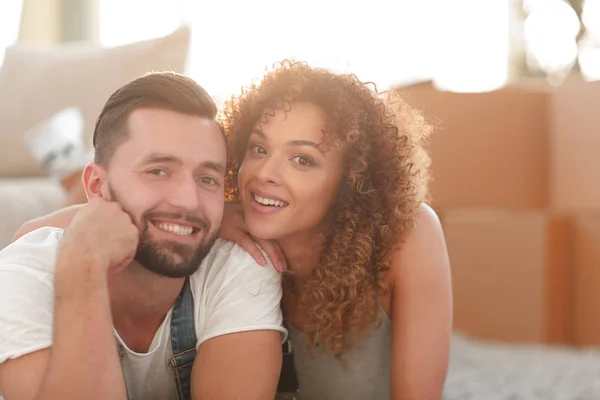 Pareja feliz acostada en la alfombra sobre el fondo borroso — Foto de Stock