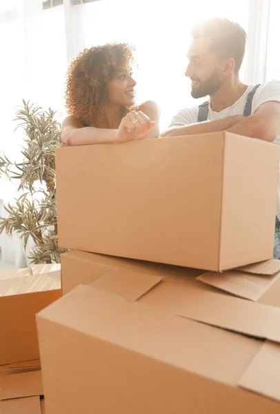 Щаслива пара, що стоїть біля коробок у своїй новій квартирі . — стокове фото
