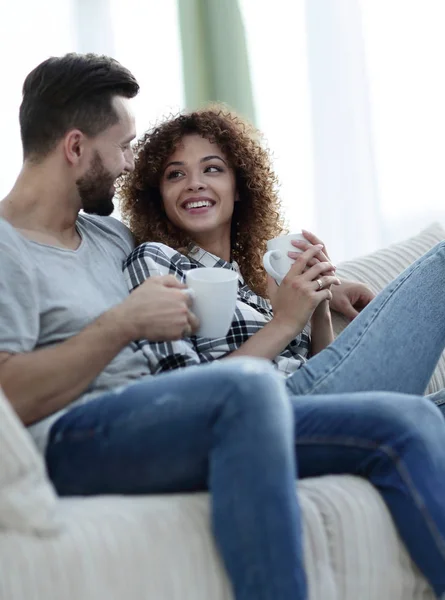 Sevgi dolu çift kanepe oturma odasında oturup çay içme — Stok fotoğraf