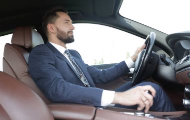 Yan emin işadamı görünümünden oturur direksiyonda bir