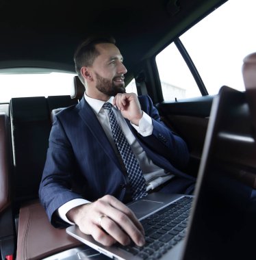 Arabanın içinde otururken kendine güvenen iş adamı